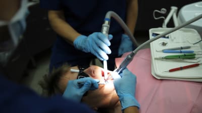 Kuvassa paikataan potilaan hampaita