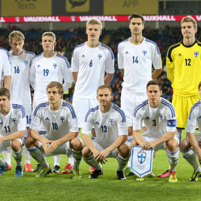 Suomen maajoukkue poseeraa joukkuekuvassa.