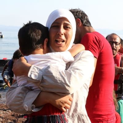Äiti kantaa lastaan turvapaikanhakijoiden veneen rantautuessa Lesbosin saarelle elokuussa 2015. Eurooppaan pyrkijöitä saapuu erityisesti Samosin, Lesbosin ja Chiosin saarille.