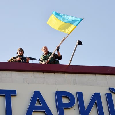 Ukraina-mielisen Donbass-ptalajoonan sotilaat heiluttavat maan lippua Lysychanskin kaupungissa 26. heinäkuuta.