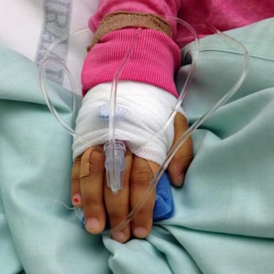 Tytön käsi sairaalan letkuissa