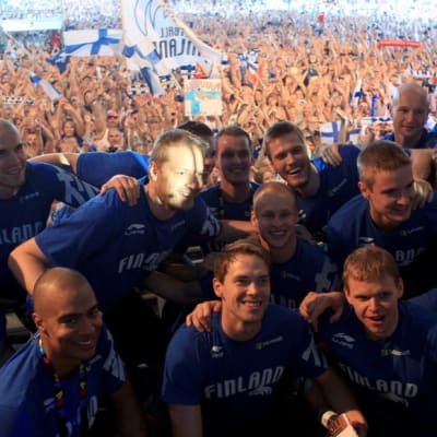 Suomen pelaajat poseeraavat fanilauman edessä.