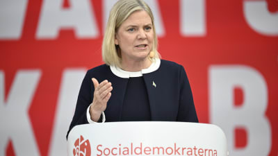 Magdalena Andersson i talarstolen, som det står Socialdemokraterna på.
