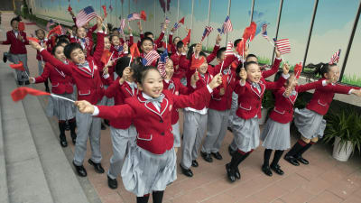 Barn viftar med USA:s och Kinas flaggor under Trumps besök i Kina.