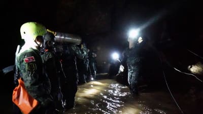 Thailändska militärer bär in förnödenheter i grottan.