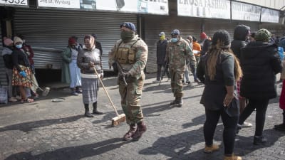 Sydafrikanska soldater patrullerar i förorten Alexandra utanför Johannesburg medan invånare städar upp efter kravaller som skakade området.