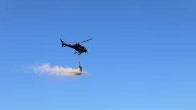 Helikopter sprider ut kalksten i Kolkkaviken i Nådendal. 