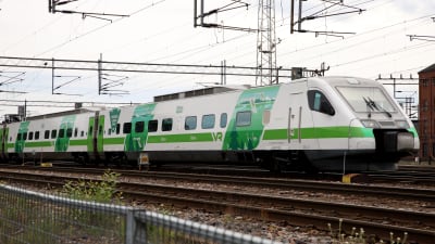 Ett grönvitt Pendolino-tåg på en bangård.