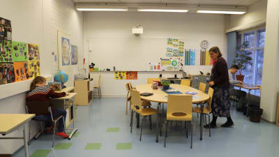 Ett klassrum med en lärare och två elever.