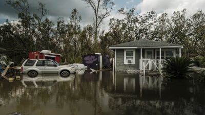 Ett hus och en bil ligger översvämmade i Barratan utanför New Orleans.