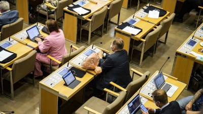 Juhana Vartiainen sitter på sin plats i fullmäktigesalen. 