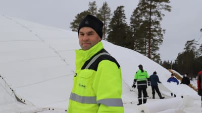 Patrick Johansson står framför en stor snöhög.