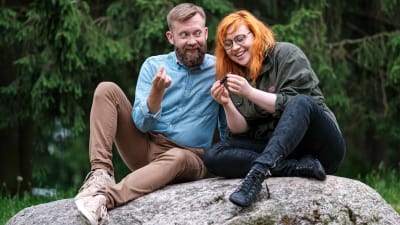 Joakim Lax och Annika Ljungberg sitter på en sten och tittar på något litet.