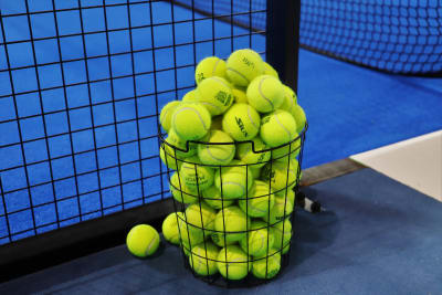 Tennisbollar i en korg.