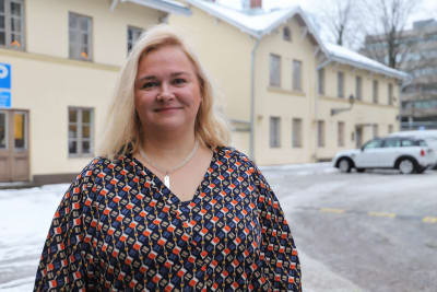 En ljushårig kvinna ler och ser in i kameran.