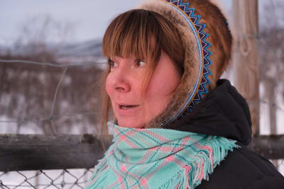 Artisten Ánnamáret med fjäll i bakgrunden, bär en samisk huvudbonad.