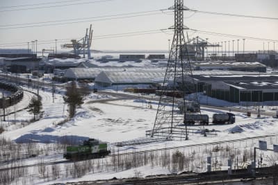 En frakthamn vintertid, i förgrunden syns järnvägsspår och ett ensamt lok.