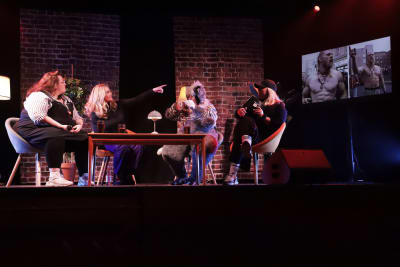 Fyra kvinnor diskuterar på en scen framför publik.