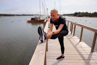 RKP:n kansanedustaja, Liikunta-, urheilu-, ja nuorisoministeri Sandra Bergqvist venyttelee jalkojaan lenkkeilyn jälkeen.