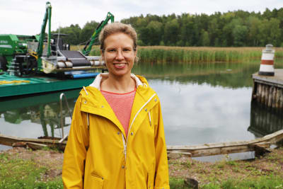 En leende kvinna klädd i gul regnrock.