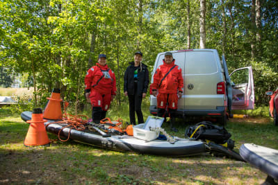 Tre forskare poserar framför sin paketbil med all sin utrustning utdragen ur bilen.