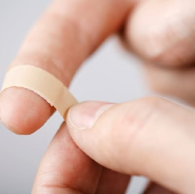 Ett plåster på ett finger.