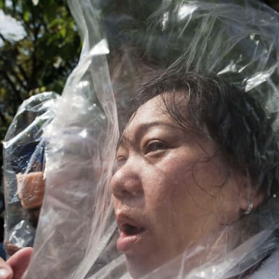 Hallituksen vastainen mielenosoittaja suojasi päänsä muovipussilla kyynelkaasua vastaan Bangkokissa 1. joulukuuta.