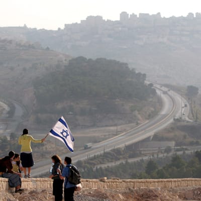 Israelilaistyttö heiluttaa lippua.