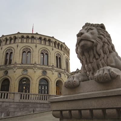 Leijonapatsas vartioi Norjan parlamenttirakennuksen ulkopuolella.