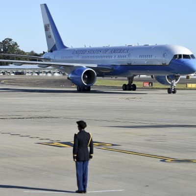 Varapresidentin lentokone, jossa teksti United States of America, pysäköitynä kentällä. Edessä seisoo vartiossa sotilas. 