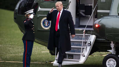 President Trump stiger ut ur helikopter, svarar på militärhonnör.