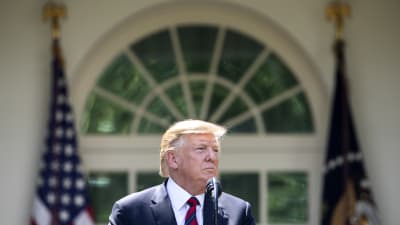 President Trump framför Vita huset i solsken