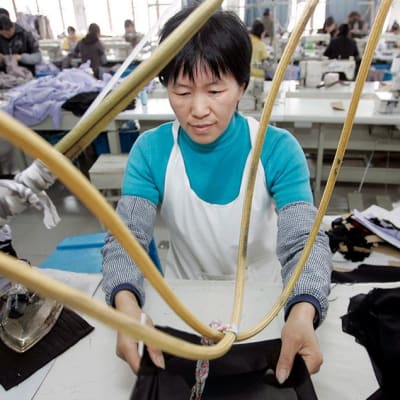 Työntekijä vaatetehtaalla Kiinan Wuzhenissa. Kuva on vuodelta 2008.
