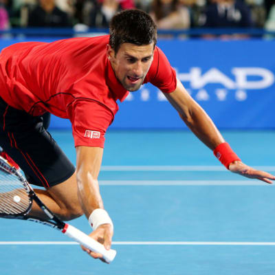 Novak Djokovic syöksyy pallon perään.