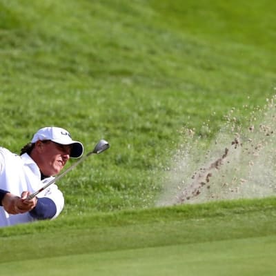 Golfari Phil Mickelson lyö pallon hiekkaesteestä.