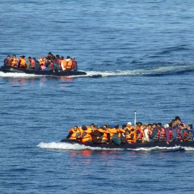 Pakolaisia kumiveneissä Lesboksen rannikolla.