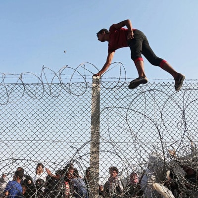 En flykting går över gränsen till Turkiet, nära staden Akcakale.