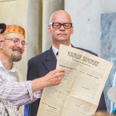 Kolme miestä esittää Rämsänrannan Runoruhtinas draamakonsertin kohtausta.