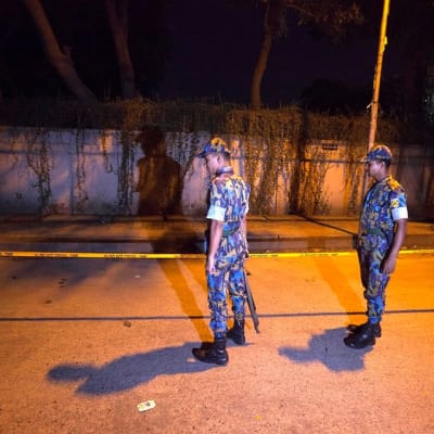 Bangladeshilaiset turvallisuusviranomaiset tarkkailevat Dhakan diplomaattialueella poliisinauhalla rajattua surmapaikkaa, missä italialainen avustustyöntekijä ammuttiin tiistaina 29. syyskuuta. 