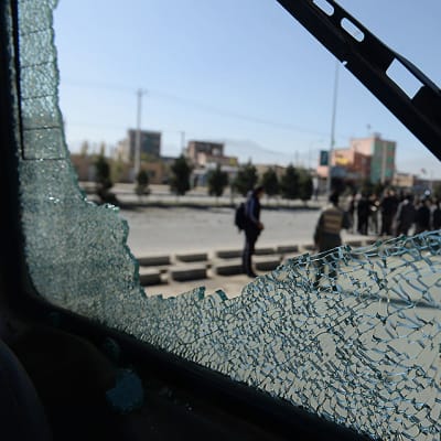 Afganistanissa räjähti kolme pommia 10. marraskuuta 2014. Talibanien asettamat pommit tappoivat ainakin kymmenen poliisia. Pirstaloituneen lasin takaa näkyy maan turvallisuusjoukkoja.