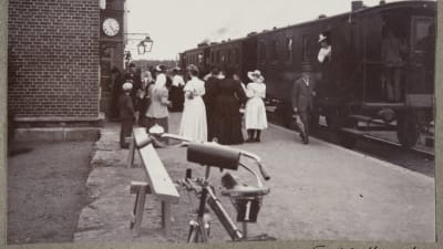 Människor vid ett tåg i svartvitt foto.