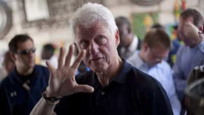 Yhdysvaltain entinen presidentti Bill Clintonilla elehtii oikealla kädellään, jonka ranteessa on Power Balance -ranneke.