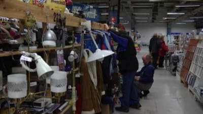 Flera personer söker bland varorna på en loppmarknad