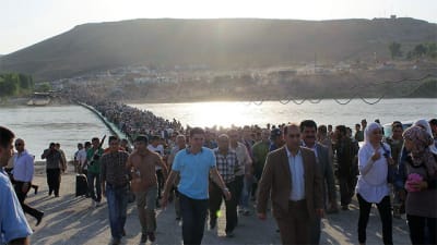Syriska flyktingar går över gränsen till irakiska Kurdistan i Duhuk