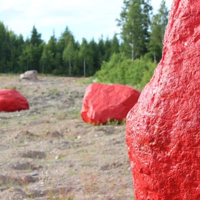 Kolme punaiseksi maalattua, isoa kiveä