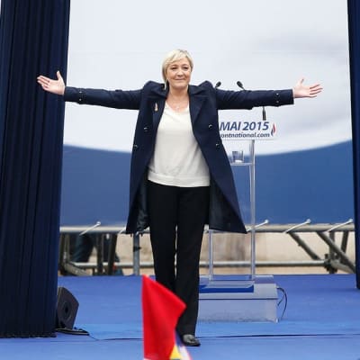 Ranskan kansallisrintaman johtaja Marine Le Pen puhujalavalla kädet levitettyinä