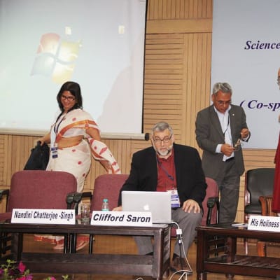 "Etiikka, Tiede ja Kasvatus" -konferenssi Delhin Yliopistossa. Neurotieteilijät Nandini Chatterjee-Singh ja Clifford Saron lavalla Dalai-laman kanssa.