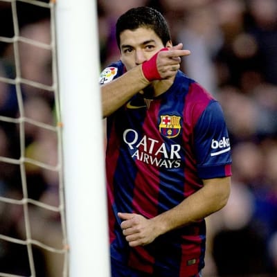Barcelonan Luis Suárez pyyhkii kasvojaan kentällä.