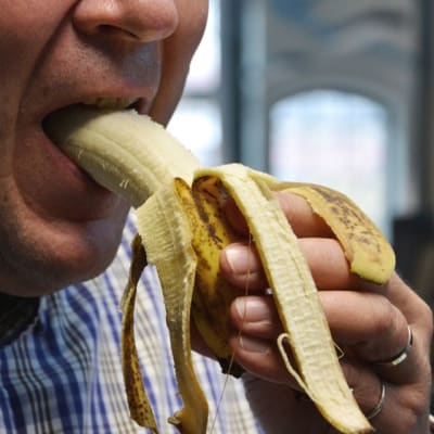 Mies syö banaania
