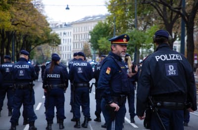 Flera österrikiska poliser står på rad på en väg.